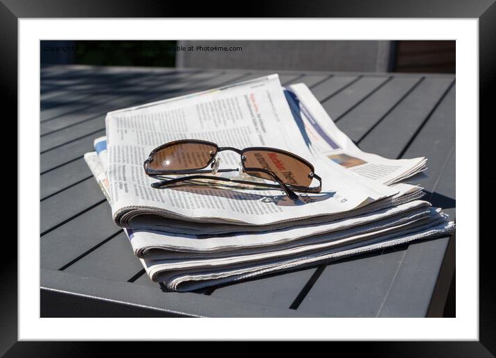 Pile of newspapers and sunglasses Framed Mounted Print by aurélie le moigne