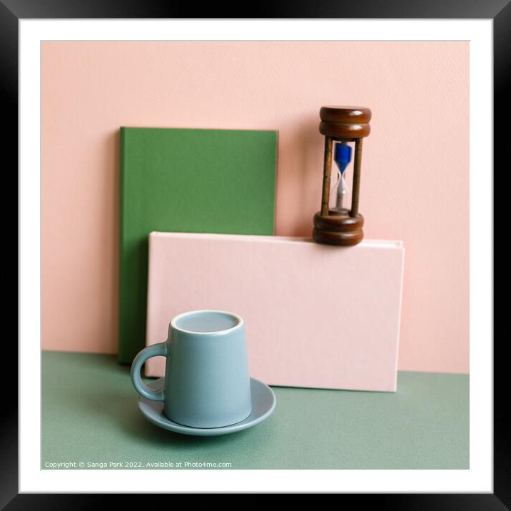 Notebook sandglass coffee cup on desk Framed Mounted Print by Sanga Park