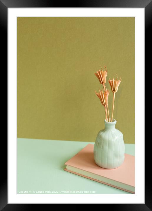 Notebook and vase of dry flower Framed Mounted Print by Sanga Park
