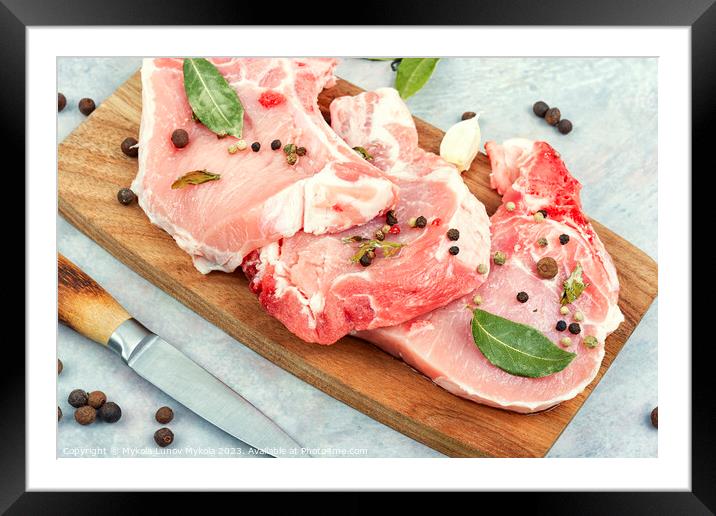 Raw pork steak in spices on a wooden board. Framed Mounted Print by Mykola Lunov Mykola