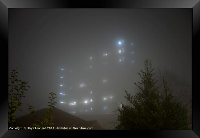 Eerie sky scraper hospital lights shine through very thick fog. Framed Print by Rhys Leonard