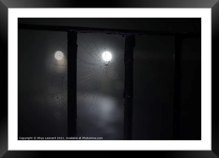 Spooky night time fog around a cobweb under railings with dew on it Framed Mounted Print by Rhys Leonard