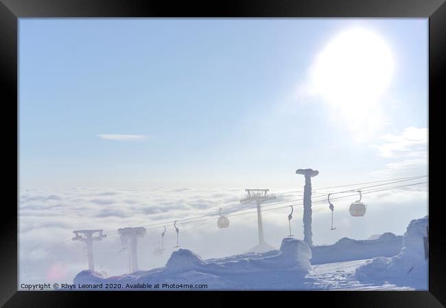 T-bar and gondola lifts emerge through the clouds into the sun Framed Print by Rhys Leonard