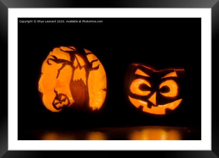 Two intricately carved halloween pumpkins lit by candle tea lights Framed Mounted Print by Rhys Leonard