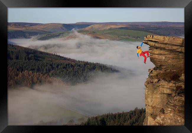 A rock climber free climbing on bamford edge in th Framed Print by MIKE HUTTON