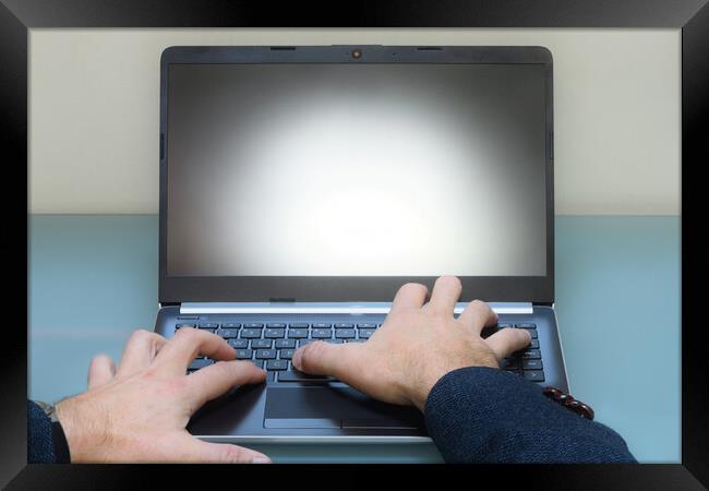 man typing on laptop computer in office on modern table Framed Print by Alessandro Della Torre