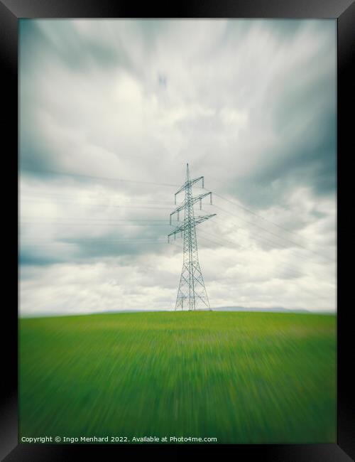 High voltage power line in the green field in Germany in the center of a radial blur Framed Print by Ingo Menhard
