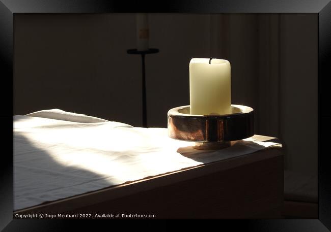 A closeup shot of a candle in the candle holder on the white cloth under the sunbeams Framed Print by Ingo Menhard