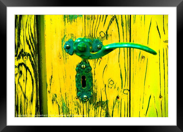 A closeup shot of an old metal handle and lock on the weathered yellow wooden door Framed Mounted Print by Ingo Menhard