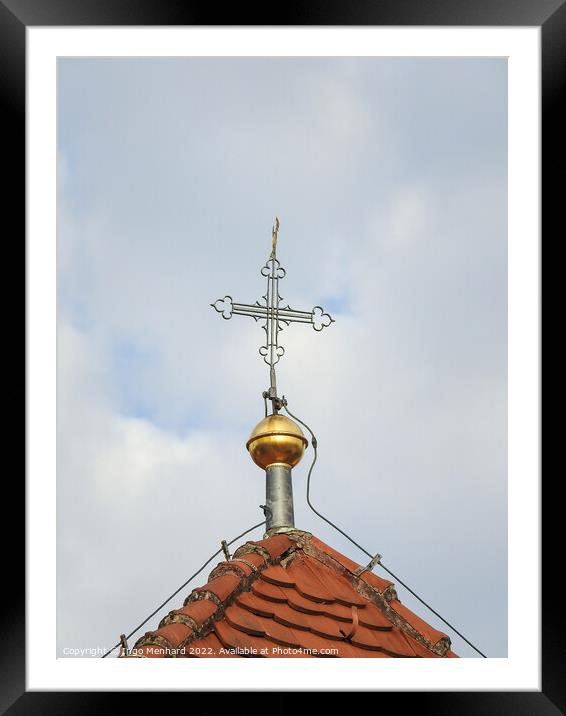 A vertical shot of a metallic cross on a cloudy sky background. Framed Mounted Print by Ingo Menhard
