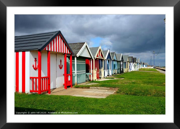 Stormy skies over beach huts in Lincolnshire. Framed Mounted Print by john hill