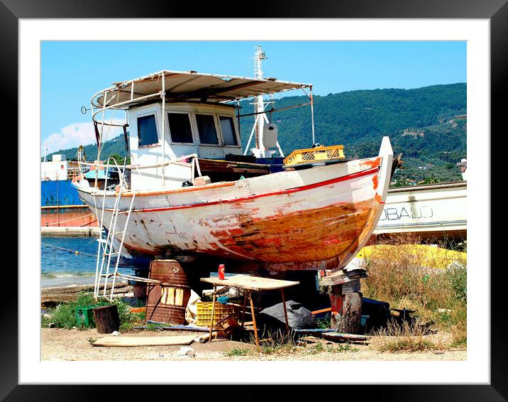 Greek fishing boat having service in Dry dock. Framed Mounted Print by john hill