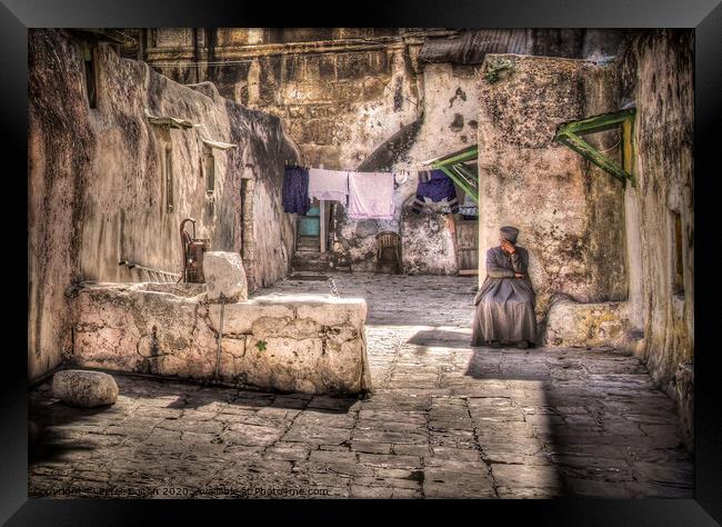 A backyard in Jerusalem old city with a resident sitting in deep contemplation.  Framed Print by Peter Bolton