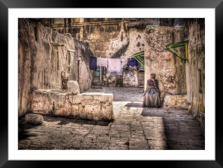 A backyard in Jerusalem old city with a resident sitting in deep contemplation.  Framed Mounted Print by Peter Bolton