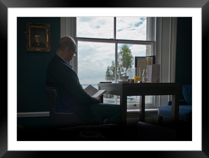 'Quiet time'. Man reading a book in front of a window. Framed Mounted Print by Peter Bolton