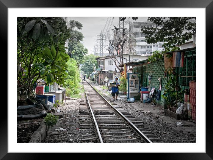 Railway track in central Bangkok, Thailand, with houses alongside. Framed Mounted Print by Peter Bolton