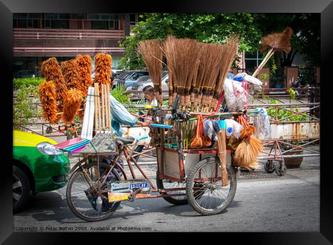 Mobile street vendor selling brushes from a pedal tricycle in central Bangkok. Framed Print by Peter Bolton