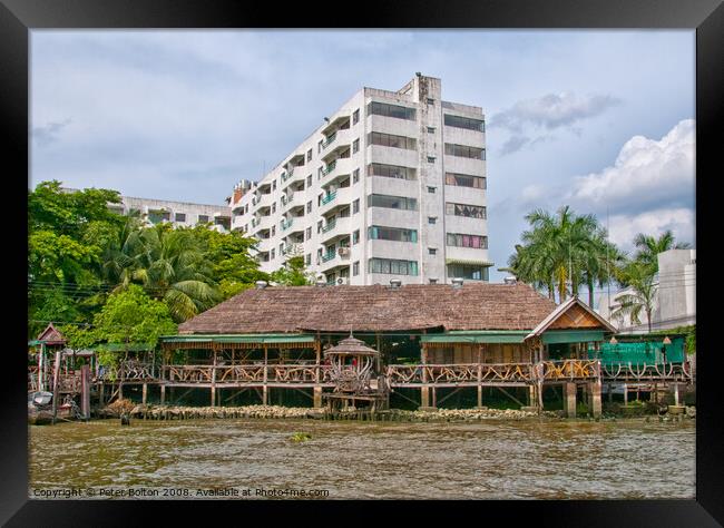 Traditional  house and modern apartment block on the Chao Phraya River, Bangkok, Thailand. Framed Print by Peter Bolton