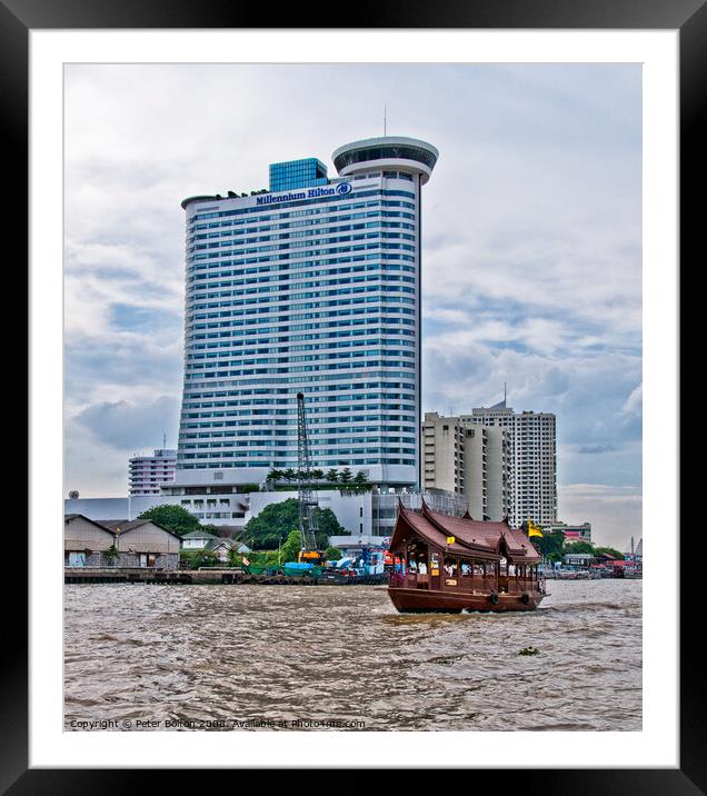 A tourist 'junk' on The Chao Phraya River passes the Millennium Hilton Hotel in Bangkok, Thailand. Framed Mounted Print by Peter Bolton
