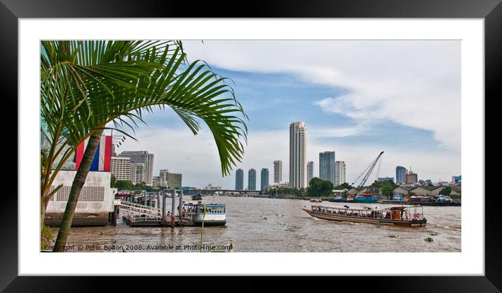 A view of ferries and landing stages on the Chao Phraya River, Bangkok, Thailand. Framed Mounted Print by Peter Bolton