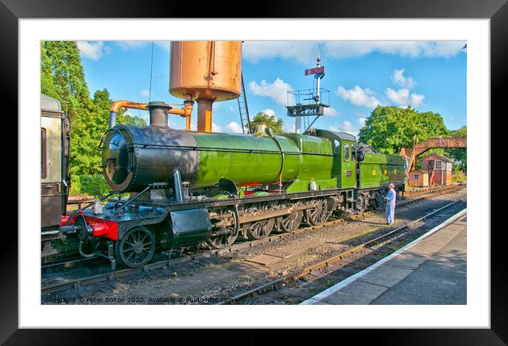 A steam locomotive takes on water at Buckfastleigh Station, Devon, UK. Framed Mounted Print by Peter Bolton