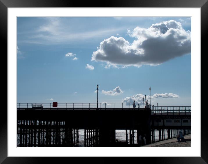 Part of the walkway in silhouette at Southend Pier, Essex, UK, with isolated clouds overhead. Framed Mounted Print by Peter Bolton