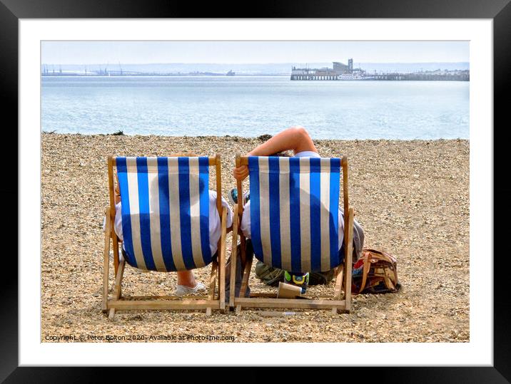 A couple on the beach in deckchairs silhouetted through the canvas at Southend on Sea, Essex, UK. Framed Mounted Print by Peter Bolton