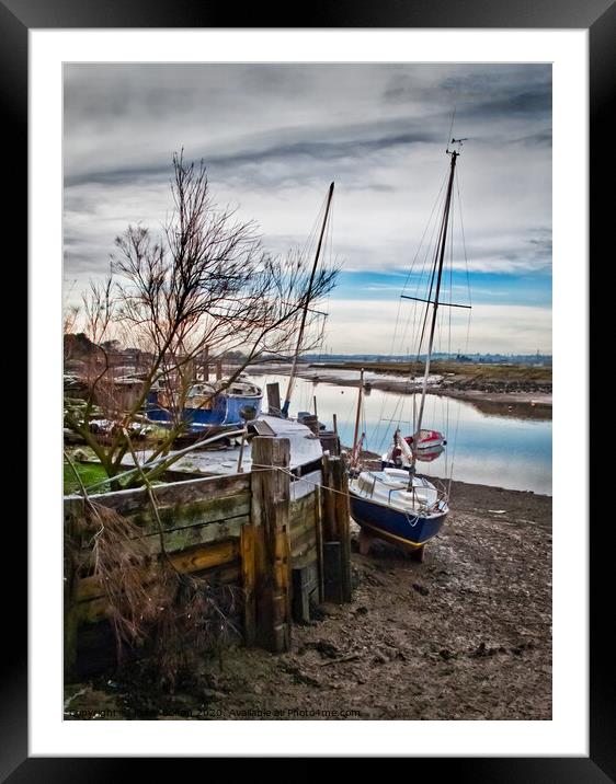A mooring dock on the River Crouch with boats waiting for the tide. Hullbridge, Essex, UK. Framed Mounted Print by Peter Bolton