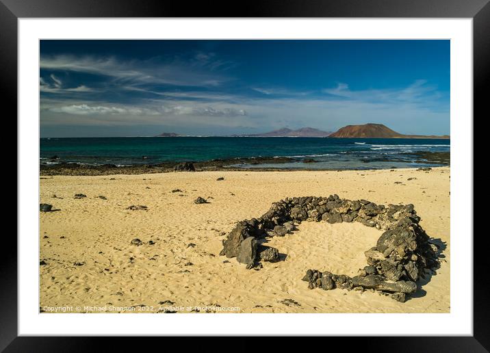 Rock beach shelter on Fuerteventura. In the distan Framed Mounted Print by Michael Shannon