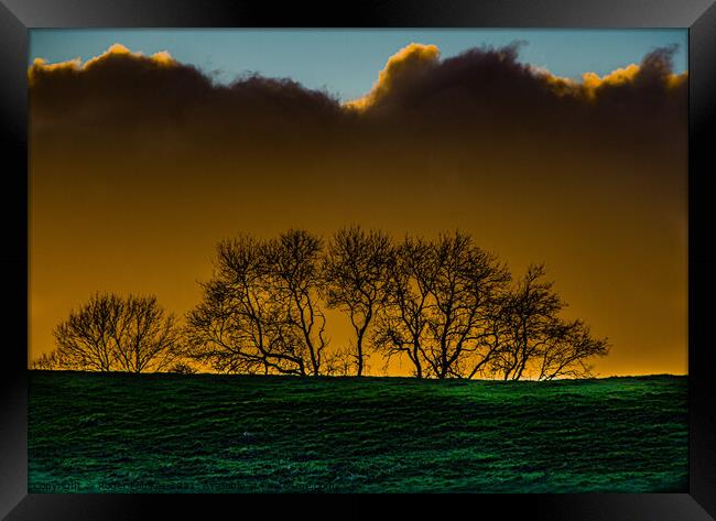 Moody SkylineA large green field in front of a sunset Framed Print by Roger Foulkes