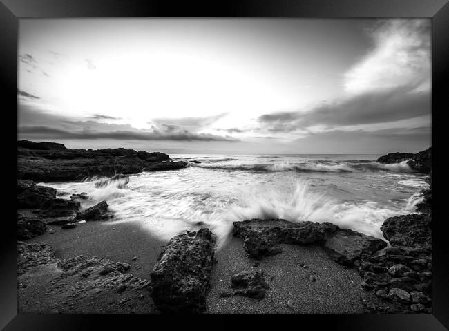 A wave crashing against the rock on a beach in black and white Framed Print by Vicen Photo