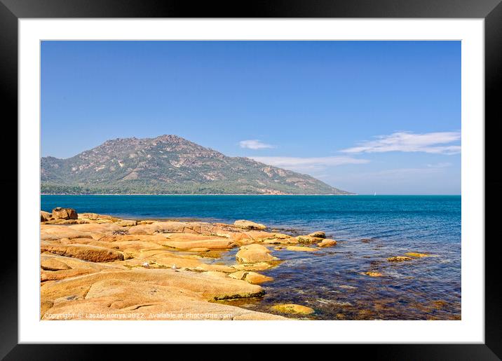 Red rocks and blue water - Coles Bay Framed Mounted Print by Laszlo Konya