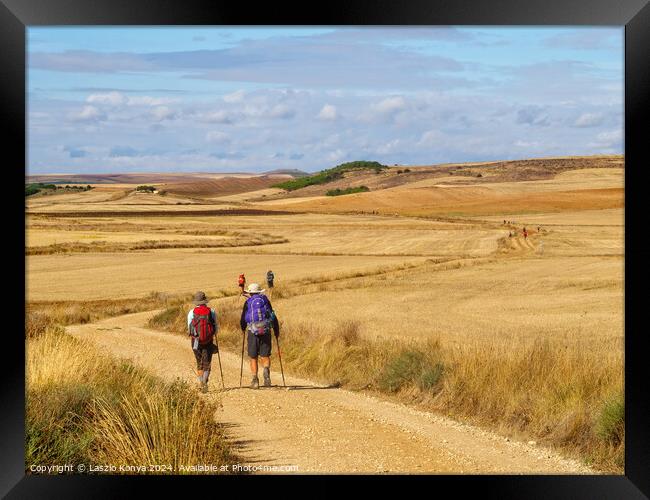 Pilgrims through the Meseta - Castrojeriz Framed Print by Laszlo Konya