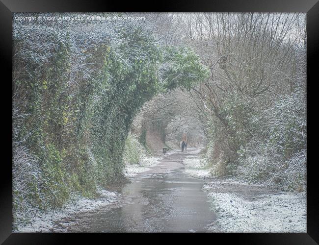 A snowy day along a path with trees  Framed Print by Vicky Outen