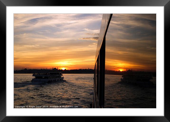 A sunset in Istanbul with the reflections on a boats windows 2 Framed Mounted Print by Engin Sezer