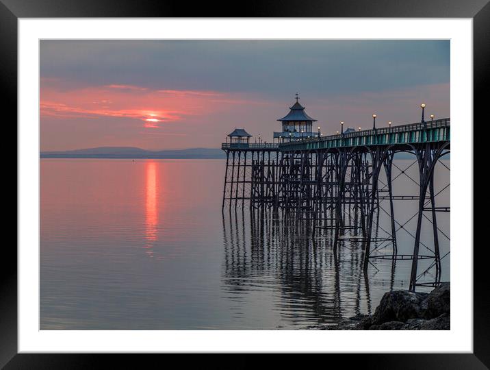 Clevedon Pier at sunset with it legs reflecting in the sea Framed Mounted Print by Rory Hailes