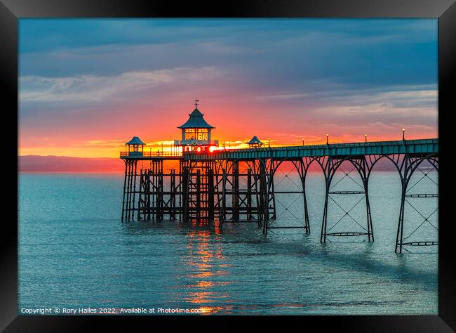 Clevedon Pier at sunset with a reddish orangey glow in the background Framed Print by Rory Hailes