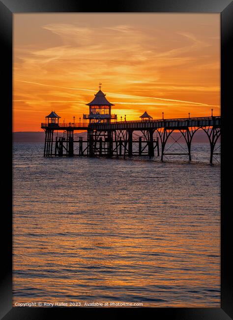 Clevedon pier at sunset with a reddish orangey glow Framed Print by Rory Hailes