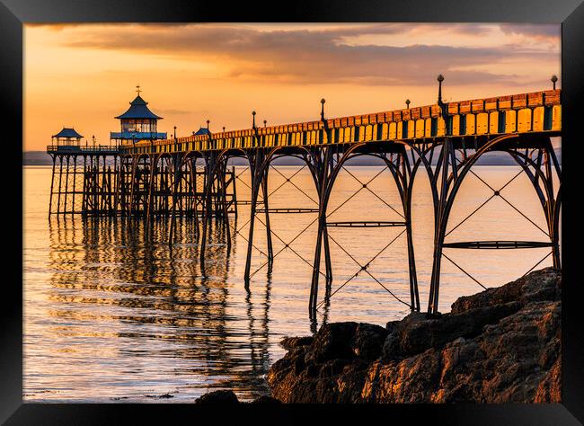 Clevedon Pier at Sunset sunlight reflecting onto the sea Framed Print by Rory Hailes