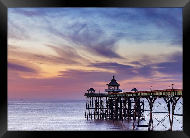 Clevedon Pier at sunset with a colourful sky and cirrus clouds catching the last of the sunlight Framed Print by Rory Hailes