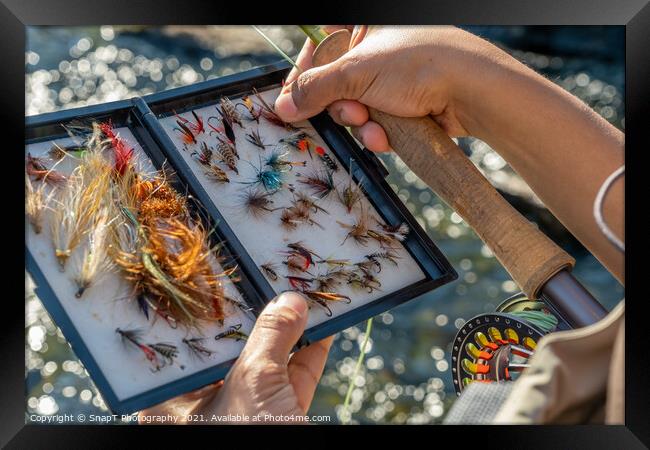 A close up of an asian female selecting fly fishing flies from a box Framed Print by SnapT Photography