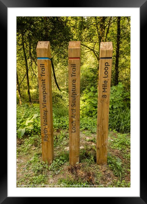Coloured wooden trail posts highlighting different trails in a Scotland Framed Mounted Print by SnapT Photography