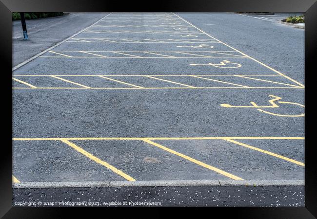 Numerous empty yellow marked disable vehicle parking spaces in a car park Framed Print by SnapT Photography
