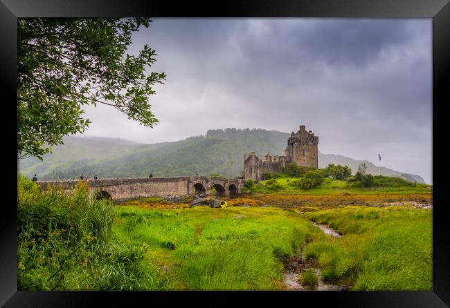 Looking out to Eilean Donan Castle, where three sea lochs meet, Loch Duich, Loch Long and Loch Alsh, on an overcast day in the Sco Framed Print by SnapT Photography