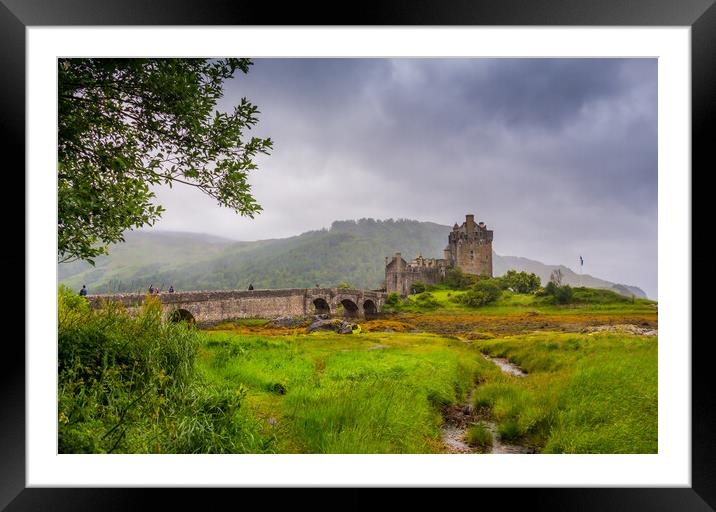 Looking out to Eilean Donan Castle, where three sea lochs meet, Loch Duich, Loch Long and Loch Alsh, on an overcast day in the Sco Framed Mounted Print by SnapT Photography