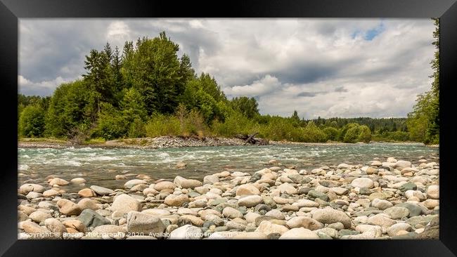 A boulder strewn, fast flowing river, beside a forest, on a cloudy day. Framed Print by SnapT Photography