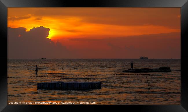 A silhouette of fishermen standing on rocks at sun Framed Print by SnapT Photography