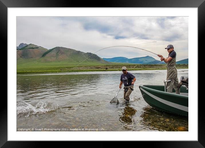 A fisherman with a Taimen Trout on the end of his line in Mongolia, Moron, Mongolia - July 14th 2014 Framed Mounted Print by SnapT Photography