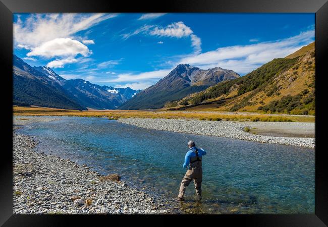 A fly fisherman casting on a beautiful mountain stream in New Zealand Framed Print by SnapT Photography