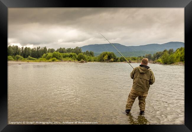 Fisherman battling a fish with a bent rod, while wading. Framed Print by SnapT Photography